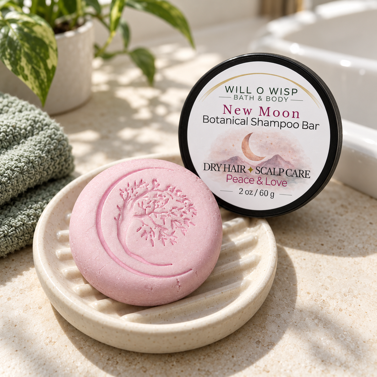 WILL O WISP BATH & BODY New Moon botanical shampoo bar in a ceramic dish with a matching label and green towel.