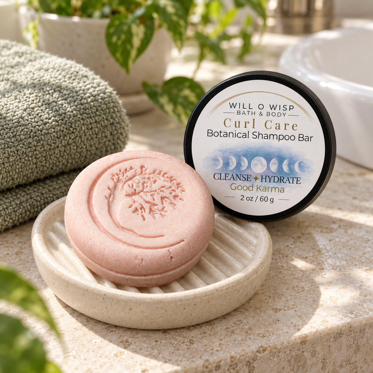 WILL O WISP BATH & BODY Curl Care botanical shampoo bar in a ceramic dish next to its branded container and green towel